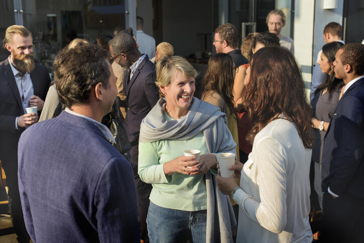 Group of people talking at an outdoor event. Group of people talking at an outdoor event.